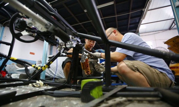 Wang and Li work on a replica of T-Rex motorcycle at a garage on the outskirts of Beijing