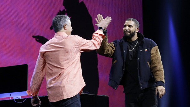 Musician Drake, right, high fives Eddy Cue, Apple senior vice president of Internet Software and Services, during the Apple Worldwide Developers Conference in San Francisco, Monday, June 8, 2015. The maker of iPods and iPhones announced Apple Music, an app that combines Beats 1, a 24-hour, seven-day live radio station, with an on-demand music streaming service. (AP Photo/Jeff Chiu)