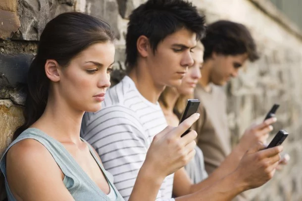 Closeup portrait of young men and women holding cellphone